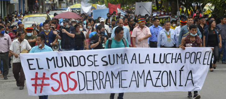 indigenous communities holding a banner reading